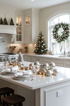 a kitchen decorated for christmas with wreaths and ornaments on the counter top, along with other holiday decorations