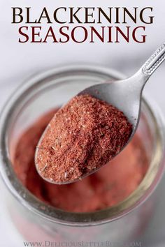 a spoon full of red seasoning sitting in a glass jar with the words blackening seasoning on it