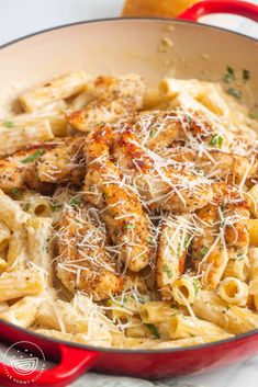 pasta with chicken and parmesan cheese in a red pan