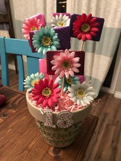 a flower pot with flowers in it sitting on a table