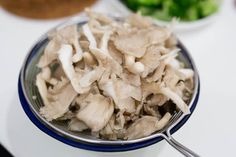 a bowl filled with mushrooms and broccoli on top of a white countertop