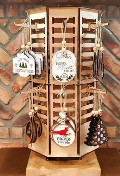 a wooden stand with christmas ornaments hanging from it's sides and tags attached to the top