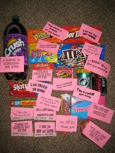 pink sticky notes and candy are on the floor next to a bottle of soda or water