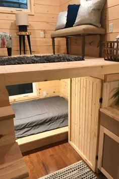 the bunk bed is built into the side of the wall in this small room with wood paneling