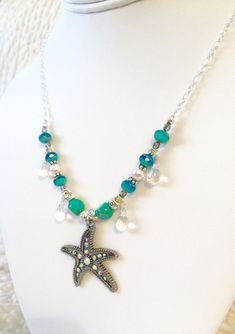 "Sparkling \"Star of the Sea\" beaded silver chain necklace featuring gorgeous 1 1/4\" x 1 3/8\" rhinestone starfish antique silver pendant. Surrounding the charm two-color Aqua designer Czech glass beads, lovely white Swarovski crystal pearls, turquoise Czech table cut beads, wire wrapped iridescent Czech glass teardrops, Czech vitrail (rainbow iridescent) beads, pewter and silver spacer beads. All strung on a pretty sparkly Sterling silver plate cable chain with unique easy to use handmade sil Beach Jewelry In Silver With Rhinestones, Bohemian Silver Jewelry With Starfish Charm, Silver Rhinestone Beach Jewelry, Bohemian Silver Necklace With Starfish Charm, Beach Silver Jewelry With Rhinestones, Silver Rhinestone Jewelry For The Beach, Silver Starfish Shaped Beaded Jewelry, Silver Beaded Ocean-inspired Jewelry, Ocean-inspired Silver Beaded Jewelry