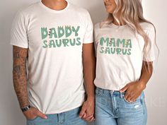 a man and woman standing next to each other wearing matching tshirts that read daddy saurrus