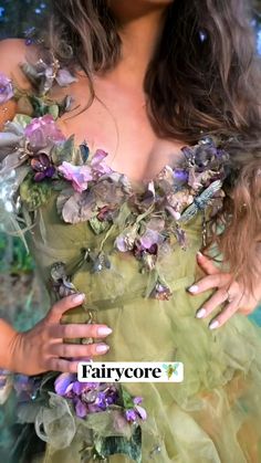 a woman in a green dress with flowers on it's chest and her hands around her waist