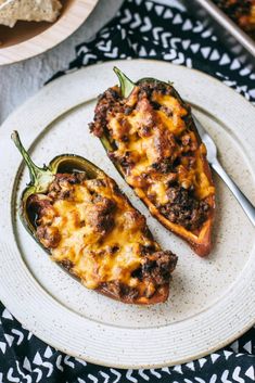 two stuffed peppers sitting on top of a white plate