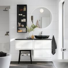 a white bathroom with a black sink and mirror