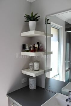 a white sink sitting under a bathroom mirror next to a shelf filled with personal care items