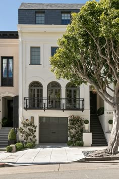 a large white house with trees in front of it