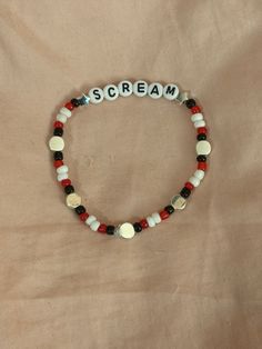 A hand-crafted glass bead friendship bracelet highlighting the slasher movie classic, "Scream"! A cute accessory to show your love for one of your favorite scary movies! This bracelet is made with Czech glass beads, plastic letter beads, plastic spacer beads, and is on an elastic thread measured at about 8 inches in length for a relaxed/loose fit. If you would like the bracelet you order to be smaller or larger, please leave the requested size in inches in the personalization box!  All bracelets Scream Bracelet Ideas, Halloween Horror Nights Friendship Bracelets, Beaded Scream Bracelet, Scream Bracelet, Horror Bracelet Patterns, Bead Bracelet Words Ideas Edgy, Horror Bracelet, The Slasher, Bead Friendship Bracelet