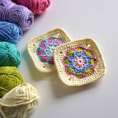 two crocheted baskets with balls of yarn next to them