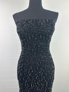 a black dress on a mannequin with sequins