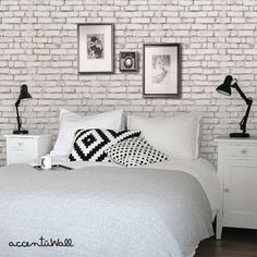 a bedroom with white brick walls and black accents on the headboard, nightstands, and bed