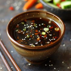 a bowl of soup and chopsticks on a table