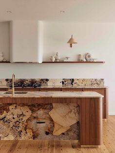 a kitchen with marble counter tops and wooden floors