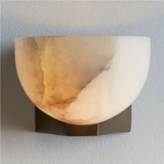 a light that is on the side of a wall with a white bowl in it