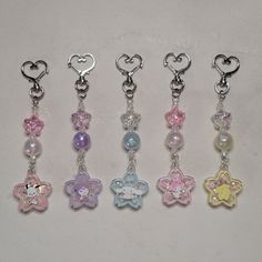 six different key chains with charms attached to each one's sides and hearts on them