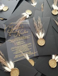 a pile of black and gold graduation caps with some white feathers on top of them