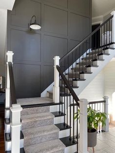 a staircase leading up to the second floor with black and white decor on either side