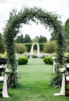 an outdoor ceremony setup with white flowers and greenery