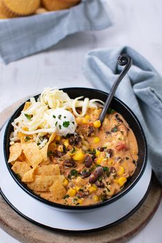 a bowl of chili and corn with tortilla chips