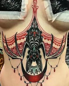 a woman's stomach with an intricate tattoo design on her belly and the back