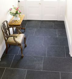 a chair sitting next to a table on top of a tile floor