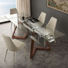 a glass dining table with white chairs around it