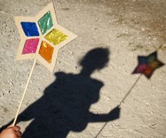 a shadow of a person holding a colorful pinwheel