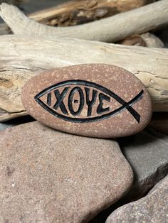 a rock with an image of a fish on it and the word love carved into it