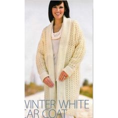 a woman wearing a white knitted cardigan standing in the middle of a road