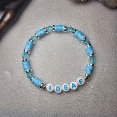 a blue beaded bracelet with the word i love you spelled in white letters on it