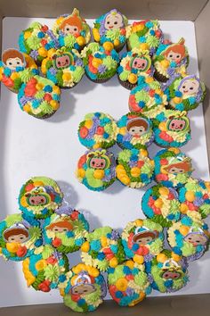 cupcakes decorated in the shape of monkeys are arranged in a circle on top of a box