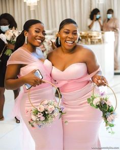 two women in pink dresses are smiling and posing for the camera while holding flower baskets