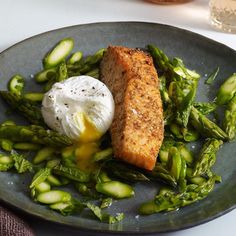 fish and asparagus on a plate with sour cream in the middle for garnish