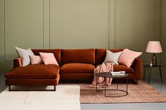 a living room with an orange couch and two lamps on either side of the couch