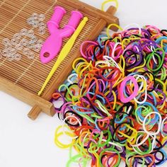 a pile of colorful rubber bands next to a pair of scissors