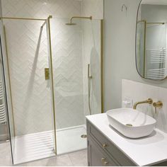 a bathroom with a sink, mirror and walk in shower next to a stand up shower