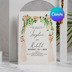 an image of wedding card with flowers and greenery on the front, next to a candle holder