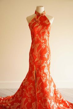 an orange and white dress on display in front of a mannequin's head