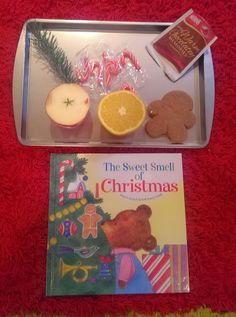 a tray filled with cookies, an orange slice and some other food items on top of a red blanket