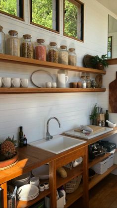 a kitchen filled with lots of open shelves next to a sink