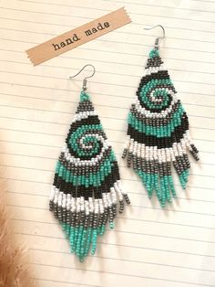 a pair of beaded earrings sitting on top of a piece of paper