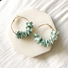 Our Anielle Flower Hoops Earrings have romantic flower petals hung on a dainty hoop. Adorn your outfit any time of the year with a splash of spring vibes with these earrings. They will look perfect with your every day tee and jeans as well as a lovely, flowy dress. Diameter about 1.5 in Delicate Spring Jewelry With 3d Flowers, Spring Flower Shaped Jewelry With 3d Flowers, Spring 3d Flowers Dangle Earrings, Spring Flower Jewelry With 3d Flowers, Chic Summer Jewelry With Flower Charm, Delicate Flower Charm Hoop Earrings, Elegant Flower Hoop Earrings For Summer, Spring Feminine 3d Flowers Jewelry, Handmade Feminine Flower Earrings For Spring