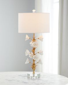 a table with a lamp and flowers on it