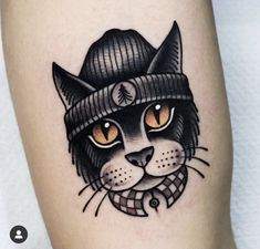 a cat with a hat and scarf on it's head is shown in this tattoo