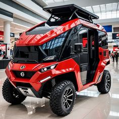 a red and black vehicle is on display in a large room with people walking around