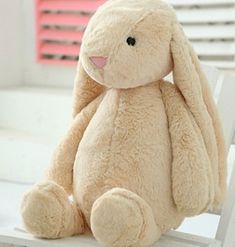 a stuffed rabbit sitting on top of a wooden chair